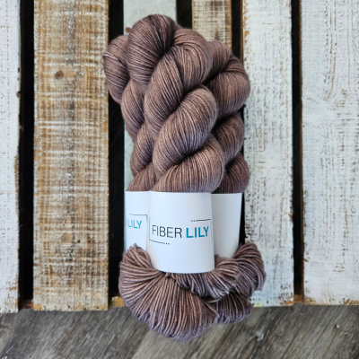 Three skeins of rich brown coloured hand dyed yarn on a wooden background