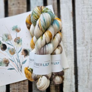 Three skeins of teal, gold, green and cream hand dyed sock yarn representing an original watercolour painting on a wooden background