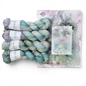 Skeins of purple and sage coloured hand dyed sock yarn representing an original watercolour painting.